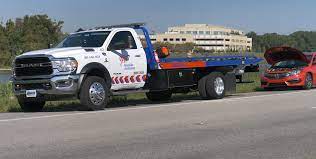 Flatbed tow truck loaded with a car